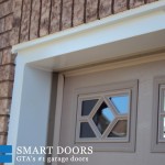 Overhead garage doors replacement in Toronto features raised panel door installed with windows