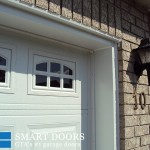 Overhead garage doors replacement in Toronto features white raised panel door installed with aluminum capping