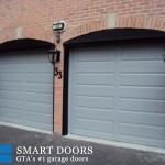 Overhead garage doors replacement in Toronto features pair of two raised panel doors in matt grey