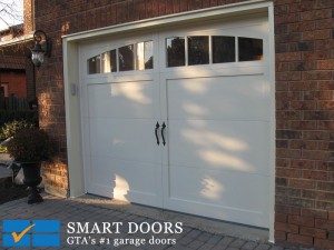 Steel short panels carriage style garage doors in white color with black hardware