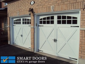 White carriage style steel frame garage doors with black hardware by Smart Doors