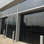 Commercial Garage Doors Installation in Toronto featuring Pair of two glossy black glass Garage Doors
