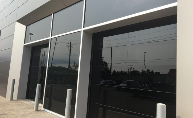 Commercial Garage Doors Installation in Toronto featuring Pair of two glossy black glass Garage Doors