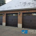 Overhead Garage Doors installation in Toronto featuring triple classic carriage style doors in wooden texture