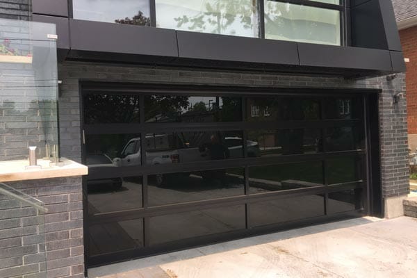 Glossy black all glass and aluminum frame garage door installed in North York