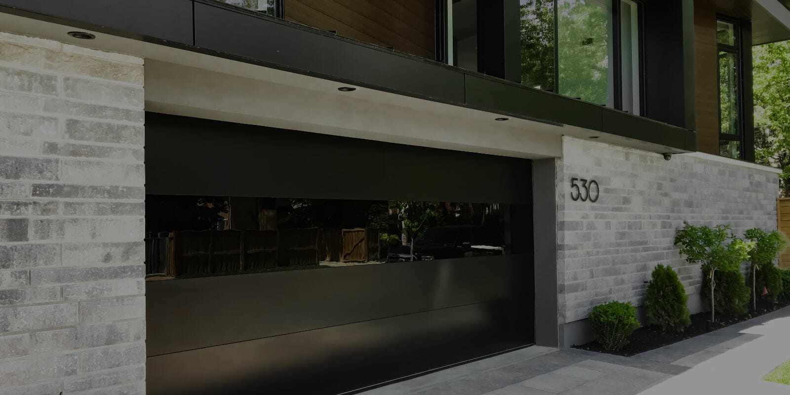 Modern all flush black garage doors with glass panel